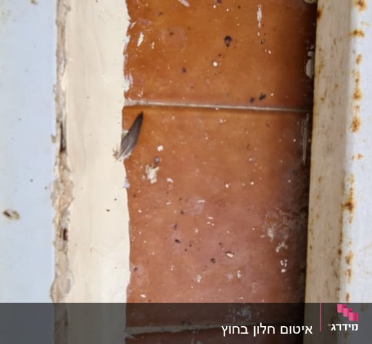 אריחים חומים עם לכלוך בין מסגרות מתכת חלודות